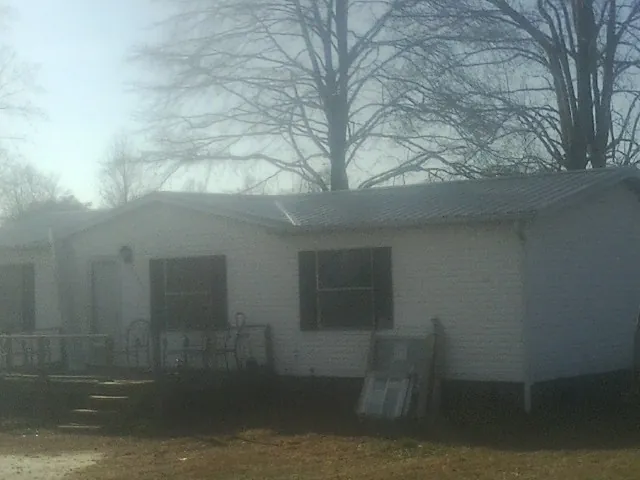 New metal roof on a white painted brick home on a foggy morning in Marietta